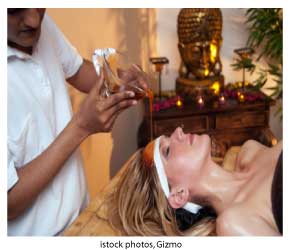 woman receiving ayurvedic oil treatment, third eye treatment