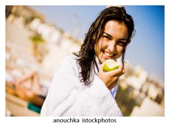 woman in white robe eating an apple at weigh loss spa