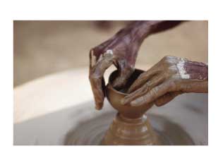 woman "throwing" a pot on a pottery wheel at a craft retreat
