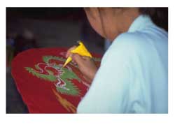 Japanese woman painting a design on fabric